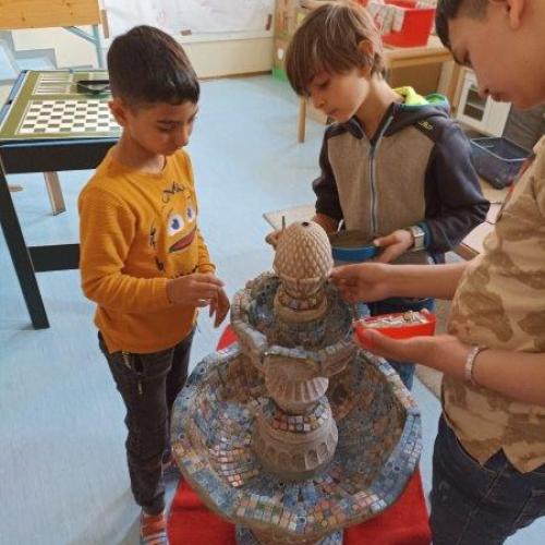 Unser Up Cycling Projekt:  Vogeltränke, Brunnen für den Schulgarten         In mühevoller Kleinarbeit werden die Mosaikfliesen aufgetragen